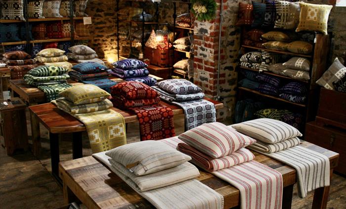 Blankets and cushions on tables in a shop